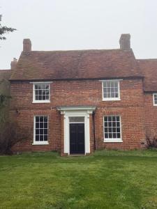 a red brick house with a black door at Superb Spacious Farm House in Henley on Thames