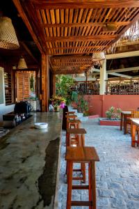 a row of wooden tables and chairs in a restaurant at Jardin Vanille in Anjiabe