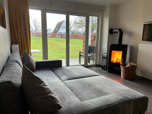 a living room with a couch and a fireplace at Ferienhauspark Asgard in Damp in Damp