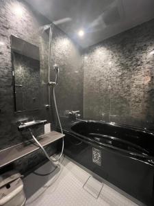 a bathroom with a black tub and a sink at Hotel U in Tokyo +26 photos