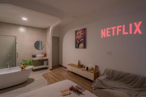 a living room with a tub and a netflix sign on the wall at Chạm's Hotel & Homestay in Ho Chi Minh City +121 photos