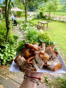 a person is holding a plate of food at Deja Vu Sapa Homestay in Sapa +61 photos