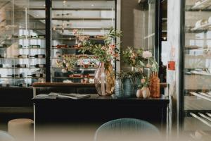 a table with a vase of flowers on it at Van der Valk Hotel Gent-Drongen in Ghent