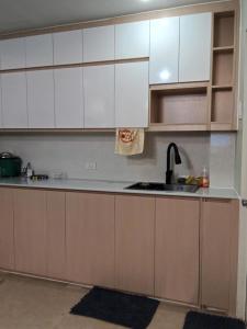 a kitchen with white cabinets and a sink at Welcome to Hambella home in Mactan