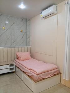 a small room with a bed with pink sheets at Welcome to Hambella home in Mactan