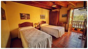 a bedroom with two beds and a balcony at Casa Rural Los campos in Corao