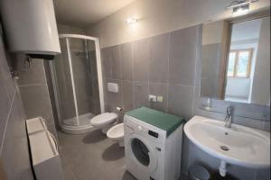 a bathroom with a toilet sink and a washing machine at Borgo Agapito in Marciana