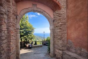 an archway in a building with a view of the ocean at Borgo Agapito in Marciana +1 photo