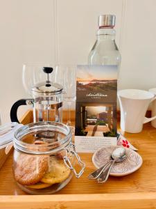 a table with a glass jar of bread and a bottle at Christiana Lodge in Plettenberg Bay