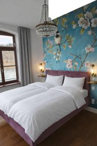 a bedroom with a large bed with a floral wall at Karmeliterhof Studios & Suites in Boppard +42 photos