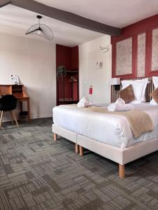 a bedroom with two large beds and a piano at Le Lion dOr Hôtel de Charme et centre ville de Bernay in Bernay
