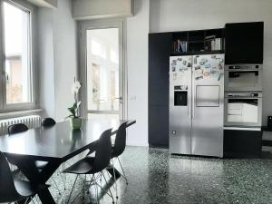 a kitchen with a table and a refrigerator at Casa vacanze I Due Tigli in Travedona