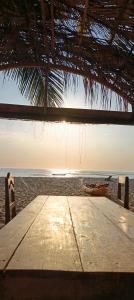 a wooden table on the beach with a view of the ocean at Villa Nianing in Nianing
