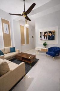 a living room with a couch and a ceiling fan at City View Residence in Islamabad