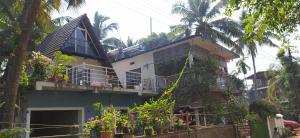 a house with a balcony with flowers on it at Arundekar's Cottage in Gokarna