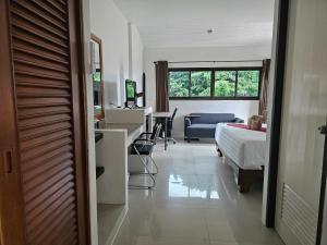 a bedroom with a bed and a desk and a table at DB Studios Samui - Adults Only in Lamai