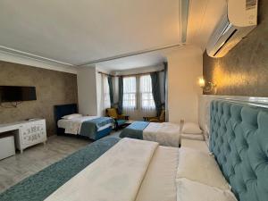 ein Hotelzimmer mit zwei Betten und einem Fernseher in der Unterkunft Urcu Hotel in Antalya