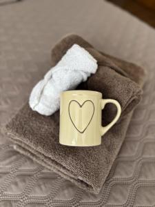 a cup with a heart on it sitting on towels at Ubytování pod Borovou in Malenovice +24 photos