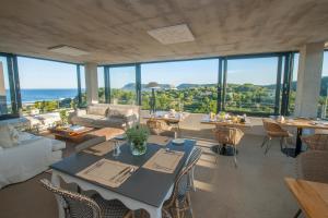 a living room with a table and chairs and the ocean at Christiana Lodge in Plettenberg Bay