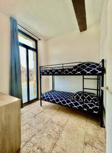 a room with two bunk beds and a large window at Cocon en petite Camargue in Aimargues