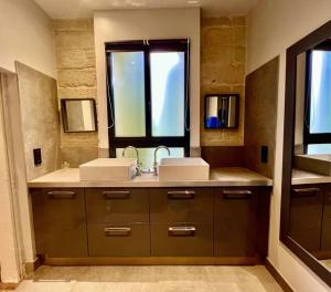 a bathroom with two sinks and a window at Cocon en petite Camargue in Aimargues
