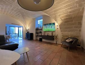 a living room with a couch and a tv at Cocon en petite Camargue in Aimargues