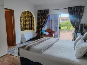 a bedroom with a bed and a window with a chair at Sun and Stars in Benoni +44 photos