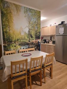 a kitchen with a table with chairs and a painting on the wall at Cabana Maly in Petroşani