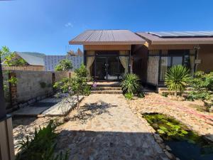 a house with a stone walkway in front of it at Cây Trôm Homestay 1 in Vĩnh Hy