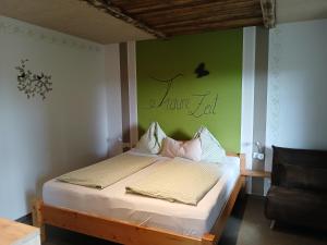 a bed in a room with a green wall at Kornihof in Waidhofen an der Ybbs