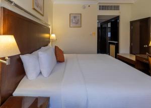 a bedroom with a large bed with white pillows at Petra Guest House Hotel in Petra