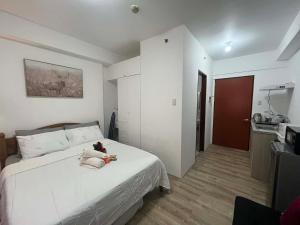 a bedroom with a white bed with a teddy bear on it at Hailey's Place Unit 2 in Bacolod