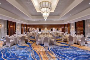 a ballroom with tables and chairs and a chandelier at Islamabad Marriott Hotel in Islamabad +189 photos