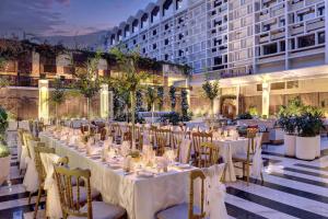 a banquet hall with tables and chairs and a building at Islamabad Marriott Hotel in Islamabad