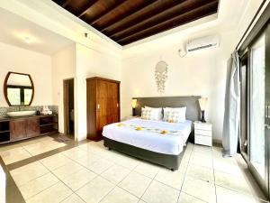 a bedroom with a large bed and a bathroom at Casa Sessy Legian in Seminyak +82 photos