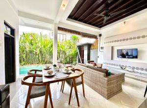 a living room with a table and a couch at Casa Sessy Legian in Seminyak