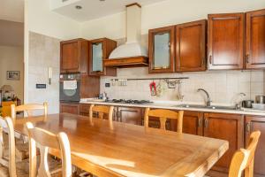 a kitchen with a wooden table and wooden cabinets at ACQUARIO DEI FRALLE in Oristano