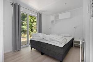 a bedroom with a bed and a large window at First Camp Glyttinge-Linköping in Linköping