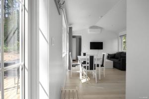 a white living room with a table and chairs at First Camp Glyttinge-Linköping in Linköping