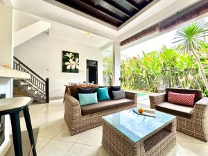 a living room with two chairs and a table at Casa Sessy Legian in Seminyak