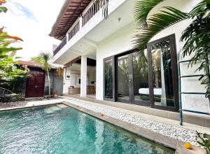 an external view of a villa with a swimming pool at Casa Sessy Legian in Seminyak