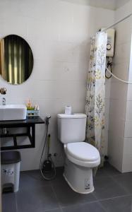a bathroom with a toilet and a sink and a mirror at Rooftop View Home in Kampot