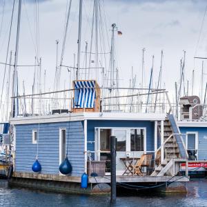 a blue boat is docked at a dock at Hausboot Baltic Goose in Burgtiefe auf Fehmarn 