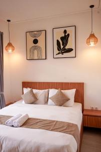 a bedroom with a bed and three pictures on the wall at Selena Home Tropical Villa Jimbaran in Jimbaran +40 photos