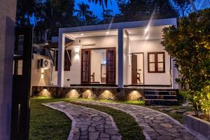 a house with a pathway leading to it at night at Villa Paddy Heaven in Unawatuna +113 photos