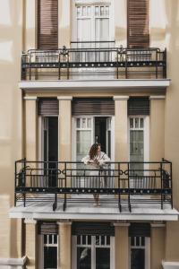 a woman standing on a balcony of a building at Ergon Bakehouse Athens in Athens +74 photos