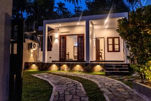 a house with a pathway leading to it at night at Villa Paddy Heaven in Unawatuna