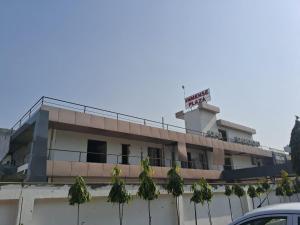 a building with a sign on top of it at Hotel Immense Plaza in Jāmb