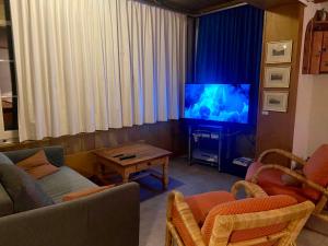a living room with a couch and a tv at Parterre-Wohnung im Zentrum in Gstaad