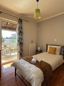 a bedroom with a bed and a balcony with a table at Spacious 3bd Apartment in Lefkakia, Nafplio in Levkákia